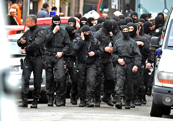 toulouse seige: Heavily armed French police officers departing the scene of the siege