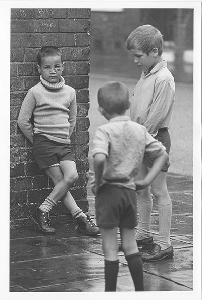 Children's Lives: Three Boys in back street, one boy with black eye