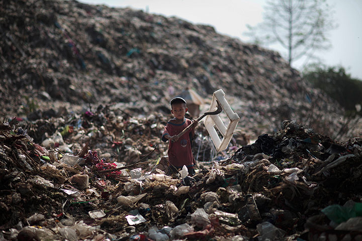 24 Hours: Mae Sot, Thailiand: A child from Myanmar scavenges rubbish