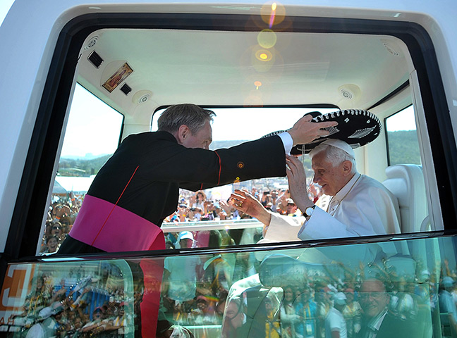 Pope visit to Mexico: Monsignor Georg Gaenswein places a Mexican sombrero on Pope Benedict 
