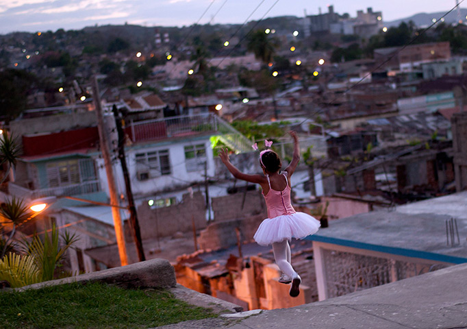 24 hours in pictures: Santiago de Cuba, Cuba: A girl wearing a ballet dress plays on the street