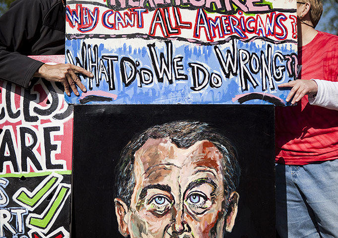 Supreme court healthcare: Healthcare reform supporters with a painting of House speaker John Boehner