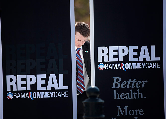 Supreme court healthcare: A member of Rick Santorum's staff sets up a backdrop outside the court
