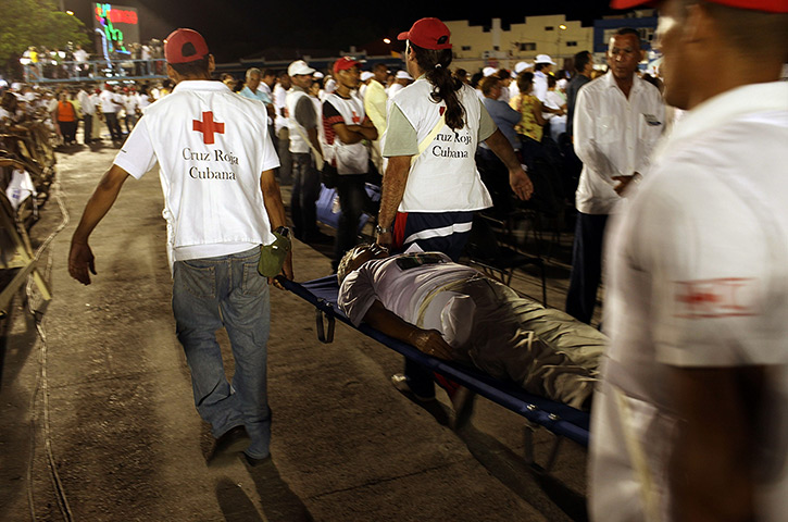Pope in Cuba: A woman overwhelmed by the heat is taken by medical personnel during mass