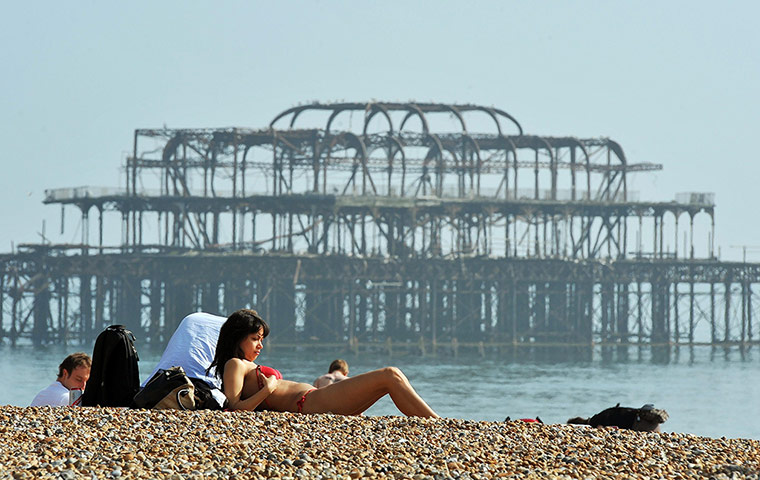 Warm Weather: Sunbathers on Brighton Beach on Saturday March 24, 2012