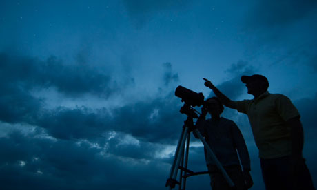 Couple using telescope on tripod