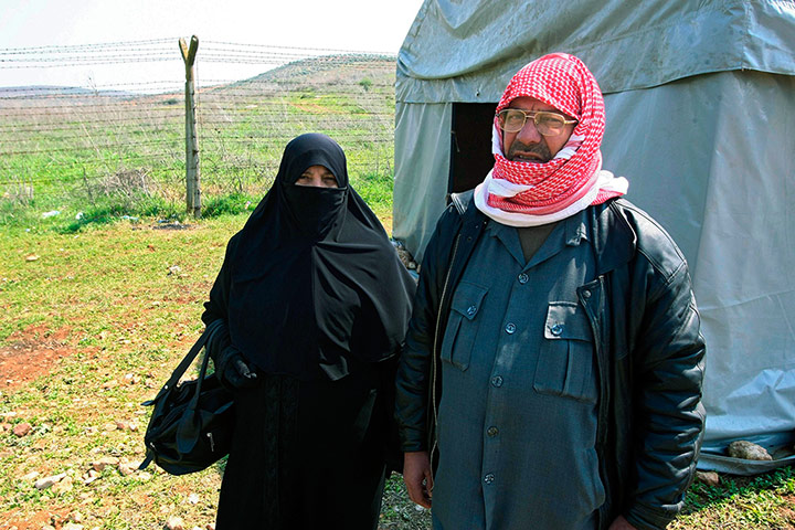 Syrian Refugees: Syrian refugees look through barbed