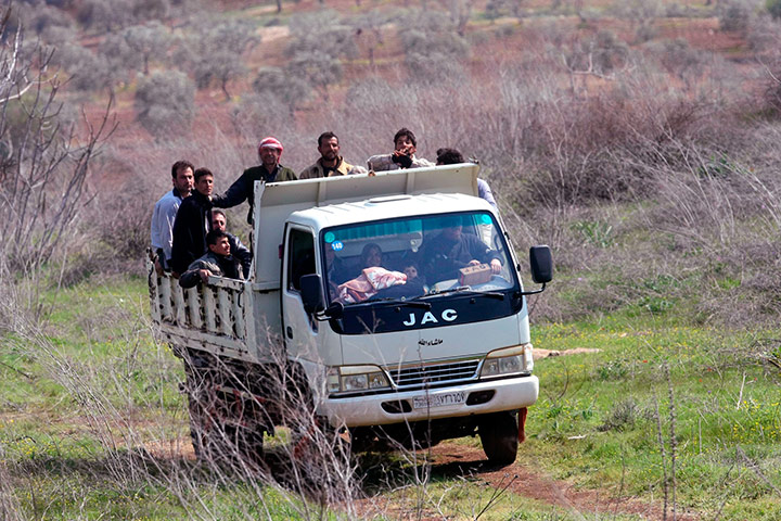 Syrian Refugees: Syrian refugees look through barbed
