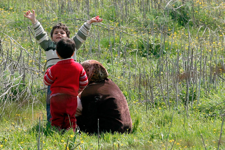 Syrian Refugees: Syrian refugees look through a barbed wire fence