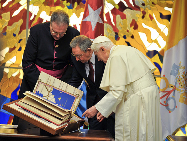Pope in Cuba: Raul Castro looks at a replica of Tolomeus Geography book given by Pope