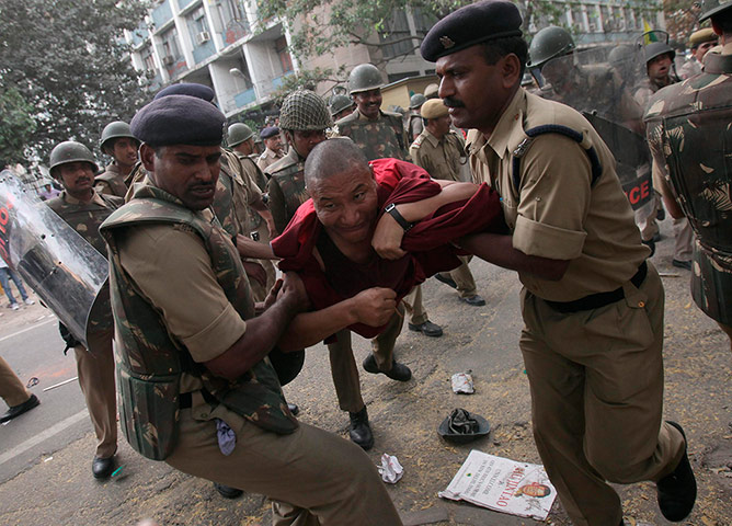 Tibet Protests: Policemen detain a Tibetan exile during a protest 