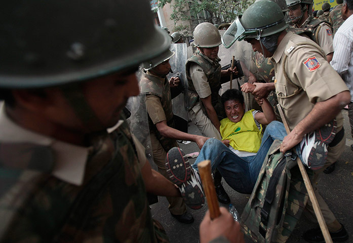 Tibet Protests: Policemen detain a Tibetan exile during a protest 