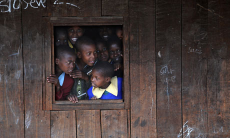 School children look through a window of their school