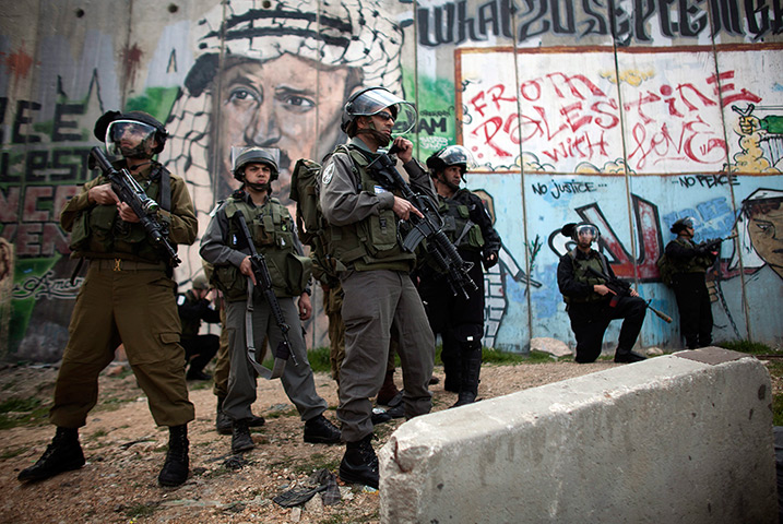 Land Day protests: Israeli border policemen stand under a painting of late Yassir Arafat
