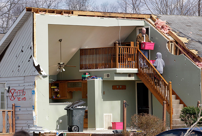 Midwest tornado: Residents carry out boxes from their damaged home in Henryville, Indiana