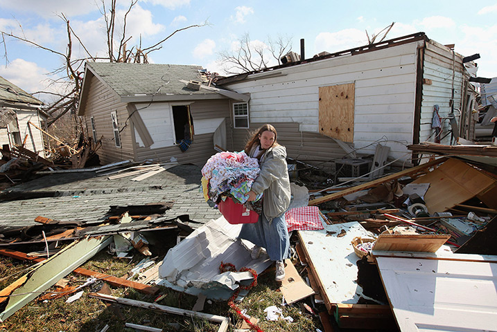 Midwest tornado: A woman helps a friend rescue possessions in Henryville