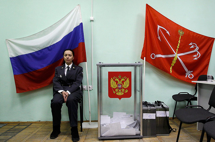Russian election: St.Petersburg: A Russian police officer sits next to a ballot box