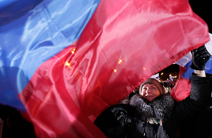 24 hours in pictures: Moscow, Russia: A supporter of  Vladimir Putin waves a Russian flag