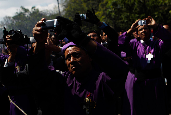 24 hours in pictures: Guatemala City, Guatemala: Catholics take pictures of a statue