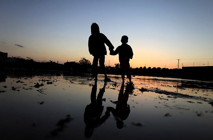 24 hours: Al Moghraka, Gaza Strip: Palestinian Bedouin boys cross a flooded road
