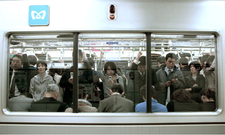Passengers using mobile phones on Tokyo subway
