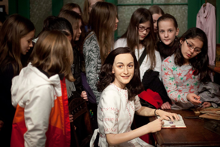 24 hours in pictures: Berlin, Germany: Students surround the wax figure of Anne Frank