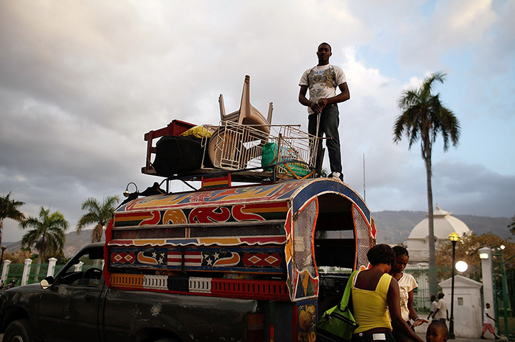 24 hours in pictures: Port-au-Prince, Haiti: A family leaves a tent camp with their belongings