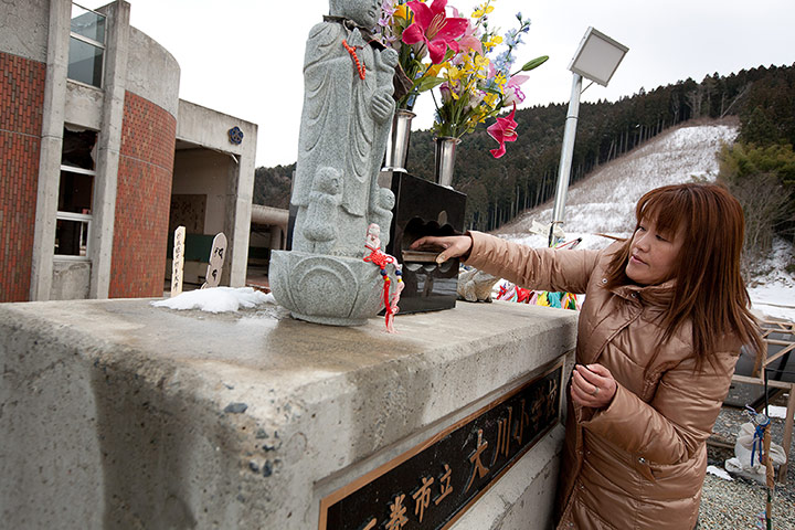 Japan tsunami: Miho Suzuki prays at a shrine to the memory of her daughter Hana