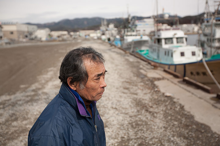 Japan tsunami: Wataru Sato, 63, stands by Kesennuma harbour as divers search