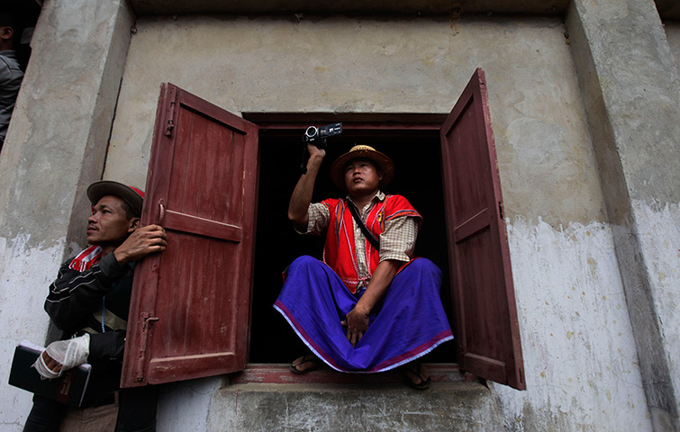 Burma elections: A man films Aung San Suu Kyi as she arrives at a polling station