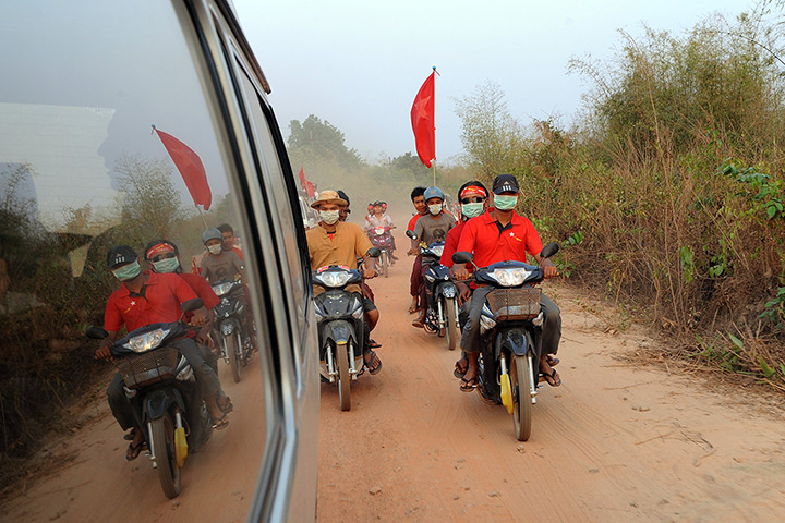 Burma elections: Supporters ride motorcycles next to Aung San Suu Kyi's car