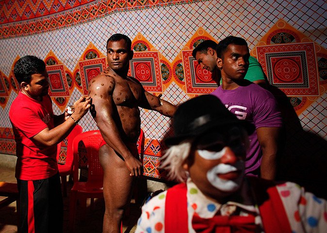 24 hours: Mumbai, India: A competitor has lotion applied at bodybuilding competition