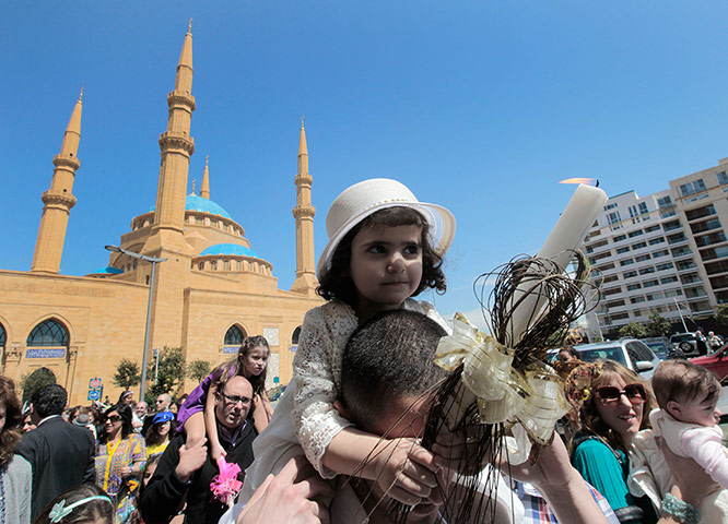 Palm Sunday: A man carries his daughter on his shoulders in front of a mosque in Beirut