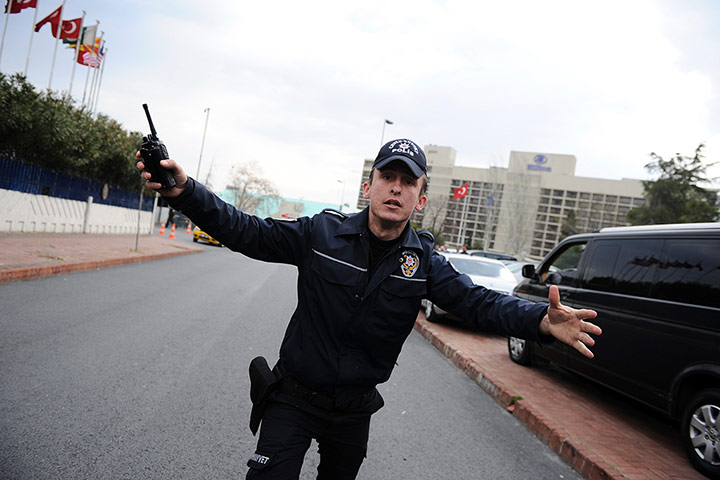 Syrian protests: A Turkish police officer tries to stop supporters of President Assad 