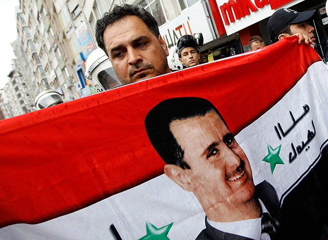 Syrian protests: A supporter waves a flag with the face of Syrian President Bashar al-Assad 