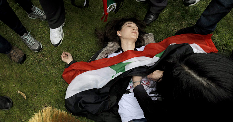 Syrian protests: A demonstrator lies on ground after Turkish riot police used tear gas 