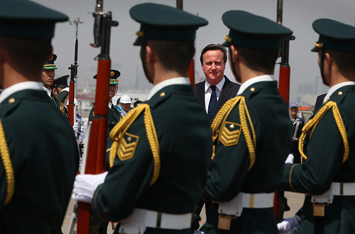 Cameron in Japan: Prime Minister David Cameron walks past a guard of honour at Haneda airport