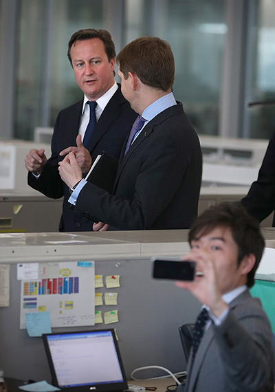 Cameron in Japan: An employee at Nissan headquarters takes a phone photograph of Cameron