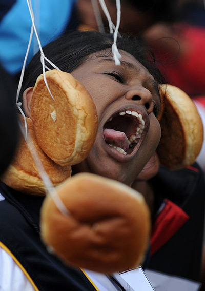 24 hours in pictures: A Sri Lankan Army soldier tries to bite a bun tied on a string