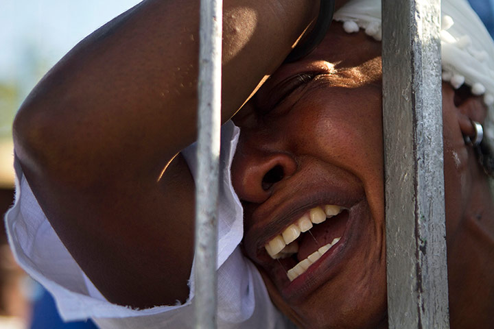 Haiti - A longer view: A woman cries as she prays during the Holy Week procession