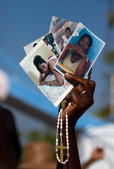 Haiti - A longer view: People bring pictures of their loved ones to the procession