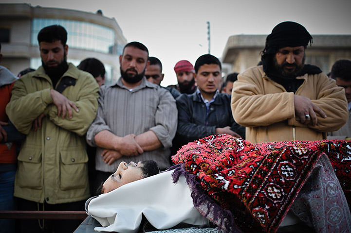 Aleppo, Syria: Men say prayers near the body of a man killed during clashes