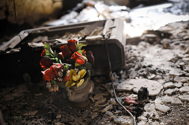 Aleppo, Syria: Plastic flowers lie amongst the burned ruins of a house