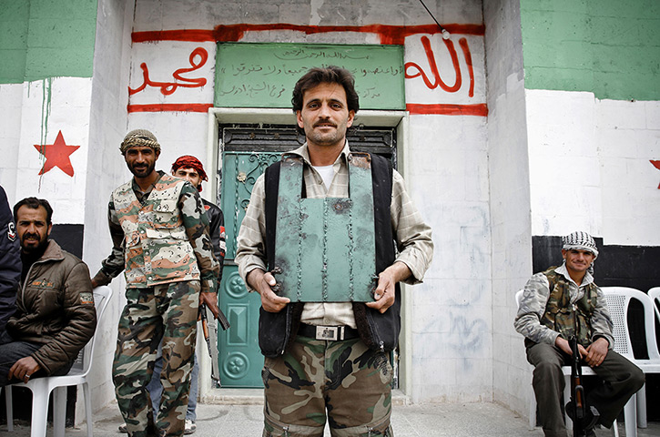 Aleppo, Syria: A rebel of the Free Syrian Army shows off his home-made body armour
