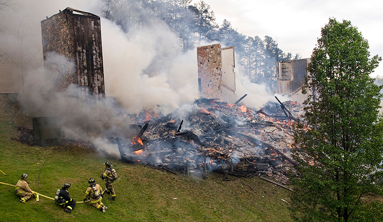 24 hours: Sevierville, Tennessee, US: Firefighters stand by a destroyed building