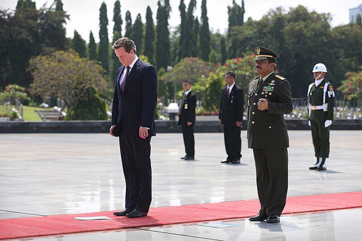 Cameron in Asia: David Cameron bows his head during a wreath laying ceremony