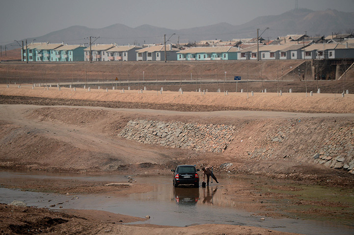 From the agencies: A North Korean man washing his car along the railway line