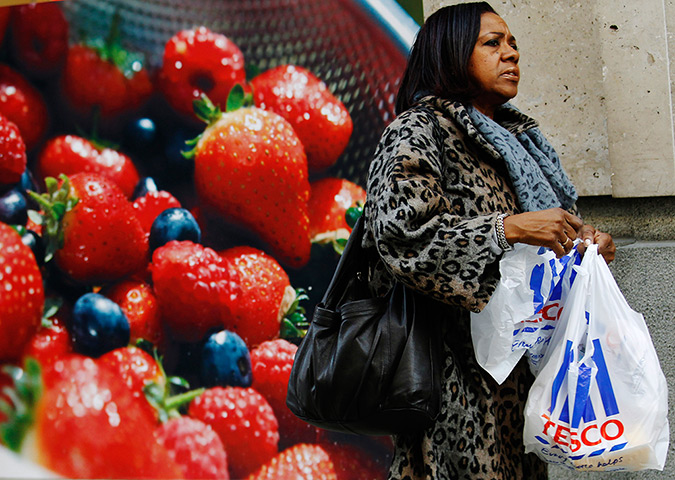 Week in Business: A woman carries a Tesco shopping bag outside a branch of the supermarket