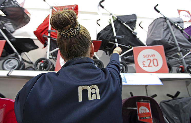 Week in Business: An employee adjusts the buggy display in a Mothercare Plc store in Thurrock