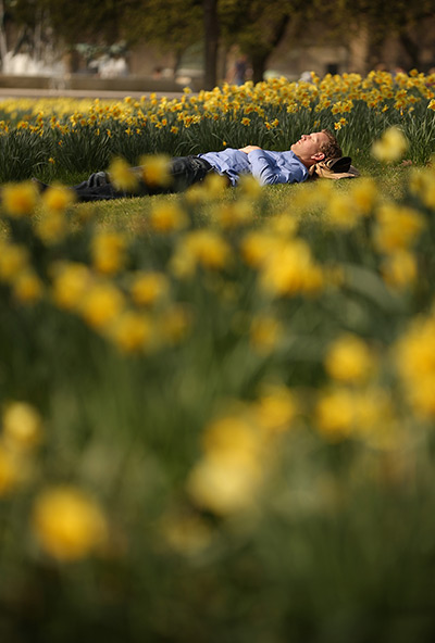 Week in Business: A man sleeps in the spring sunshine in Hyde Park